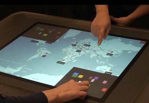 photo of two users' hands interacting with a touch-sensitive table using the Access Overlays tool to gain understanding of a large map accessible without sight